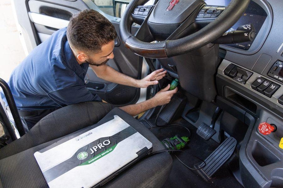 NH Repairs technician working on commercial truck mechanical components in Pompano Beach shop